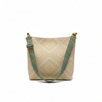 Beige tote bag with green strap on a windowsill